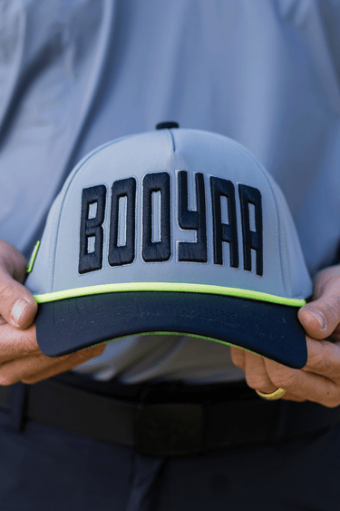 BooYaa Premium Golf Cap - BOLD GREY, gray and navy cap with neon yellow trim, front detail in hands
