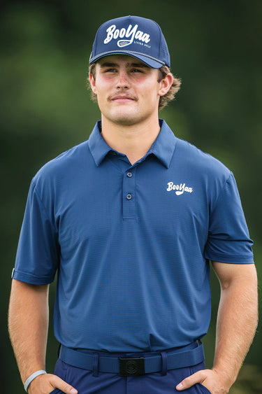 Golfer in the Oxford Navy Vintage golf polo and a navy BooYaa cap, front view