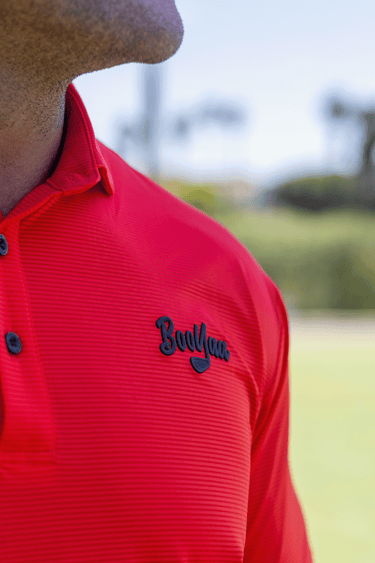 Close-up of the black BooYaa chest logo on the Tiger Red Vintage golf polo